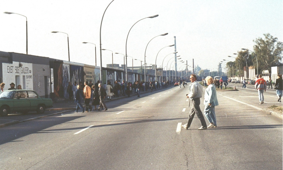 Personen spazieren auf der Straße an der East Side Gallery